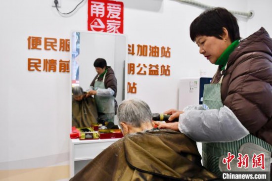 胡玉斐(右一)在當地公益站忙碌。羅夢圓 攝